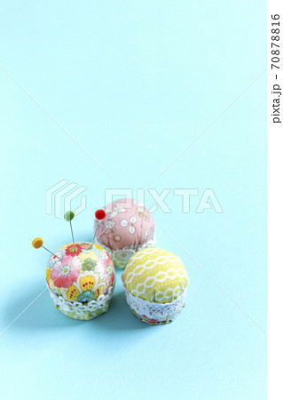 ミニカップケーキ風ピンクッション 水色背景 縦位置の写真素材