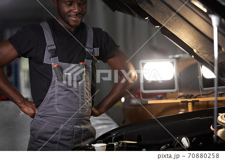 serious afro american male stand above car thinking 70880258