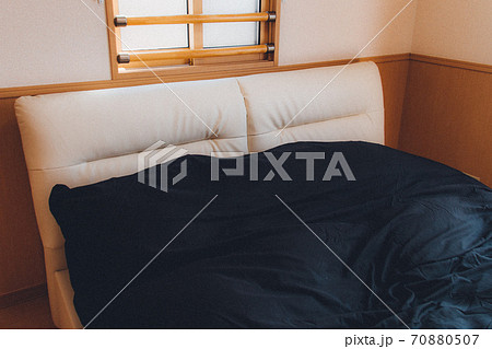 ベッドルーム 寝室 白いダブルベッドと黒い掛布団の写真素材