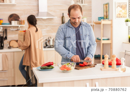 Husband chopping tomatoes 70880762