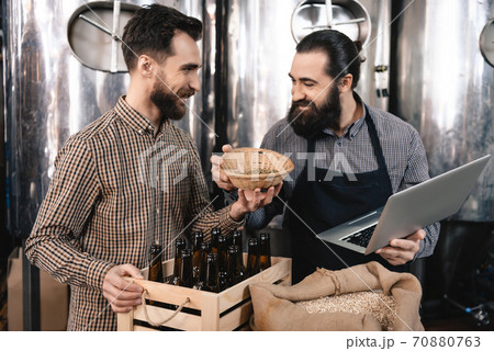 A man shows brewing seeds to a colleague. A man shows brewing seeds to a colleague. 70880763