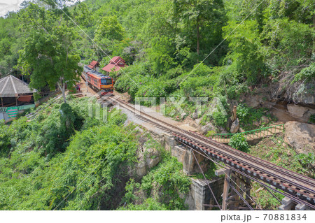 Aerial view of Thai local old classic train on railway on River Kwai Bridge in Kanchanaburi town, Thailand in public transportation concept. 70881834