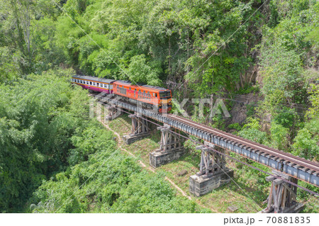 Aerial view of Thai local old classic train on railway on River Kwai Bridge in Kanchanaburi town, Thailand in public transportation concept. 70881835