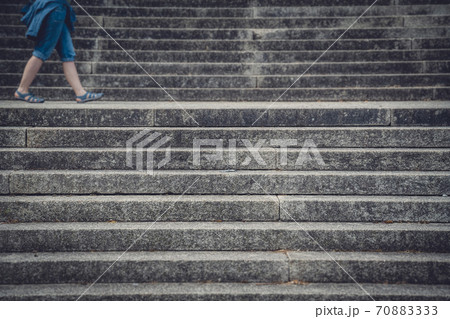 Legs of a woman walking between concrete stairs 70883333