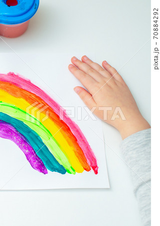 Kid painting rainbow during quarantine at home. 70884292