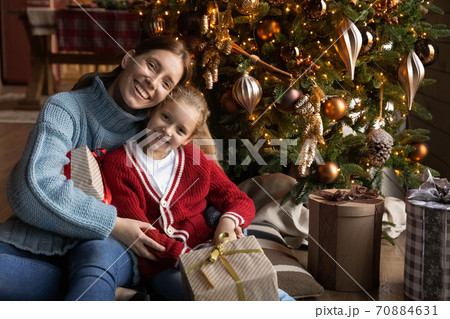 Portrait of loving mother and little daughter near Christmas tree 70884631