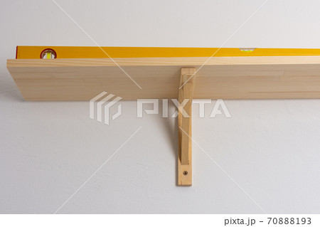 The process of attaching a wooden shelf to the wall The process of attaching a wooden shelf to the wall 70888193