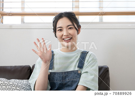 カメラ目線で手を振る若い女性 カメラ目線で手を振る若い女性 70889926