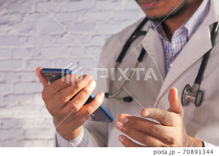 close up of doctor hand using smart phone indoor close up of doctor hand using smart phone indoor 70891344
