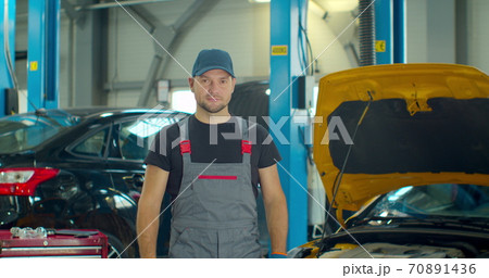 Portrait of a young beautiful car mechanic in a car workshop, in the background of service. Portrait of a young beautiful car mechanic in a car workshop, in the background of service. 70891436
