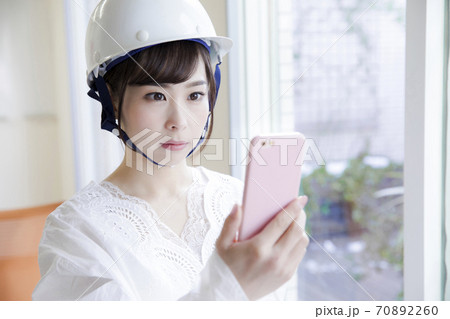 災害通知を見る女性 70892260