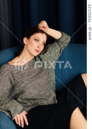 Beautiful young woman in grey sweater and disco ball at home 70892529