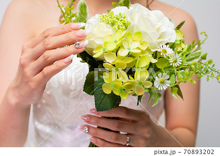 ブライダルネイルとブーケを持つ女性 70893202