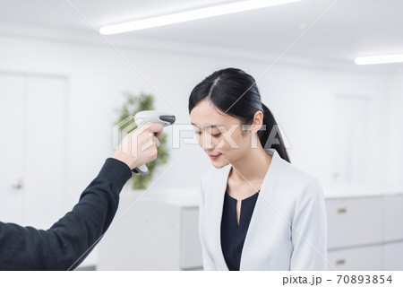 検温する女性 非接触式電子体温計 検温する女性 非接触式電子体温計 70893854