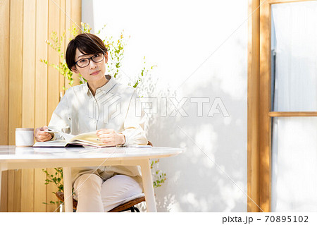 女性　テラス　読書　くつろぐ　ライフスタイル 70895102