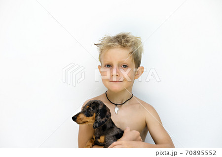 Funny portrait of little child embracing dachshund puppy 70895552