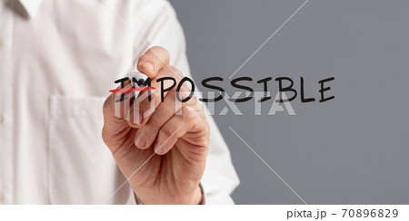 Businessman Crossing Out Word Impossible Making Everything Possible, Gray Background Businessman Crossing Out Word Impossible Making Everything Possible, Gray Background 70896829