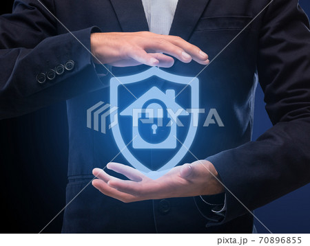 Man in suit holding hologram of locked house in hands 70896855