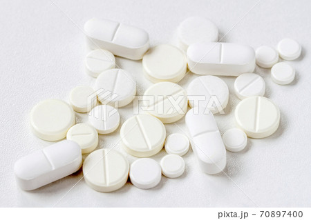 Medical background with light color pills, top view. Concept of health, pharmaceutical industry, medicine, treatment of illness. Medical background with light color pills, top view. Concept of health, pharmaceutical industry, medicine, treatment of illness. 70897400