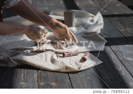 Close up picture of female ceramic artist arms in clay after making pottery. 70899112