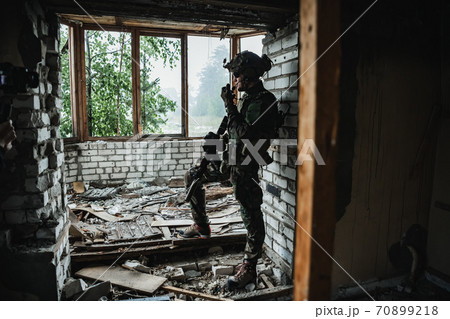 Soldier talking on the walkie-talkie inside the building, military concept 70899218