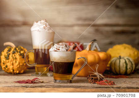 Pumpkin spice latte with cinamon powder and delicious flavours on the old textured wood table with colorful dry leaves and pumpkins Pumpkin spice latte with cinamon powder and delicious flavours on the old textured wood table with colorful dry leaves and pumpkins 70901708