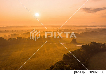 Sun rising above riparian forest in summer from drone Sun rising above riparian forest in summer from drone 70902334