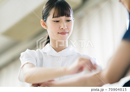患者の腕を消毒する看護師 患者の腕を消毒する看護師 70904015