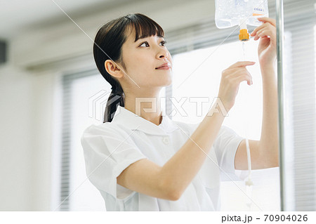 点滴の準備をする女性看護師の写真素材