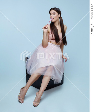 attractive brunette holding a candy in the form of cheese 70904312