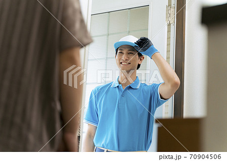 玄関に立つ作業服の男性_引っ越し、宅配 70904506