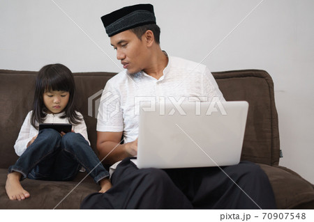 male sitting with his daughter using laptop male sitting with his daughter using laptop 70907548