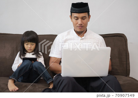 male sitting with his daughter using laptop male sitting with his daughter using laptop 70907549