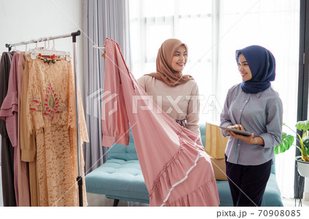 portraits of beautiful muslim women shopping for clothes and chatting with seller 70908085