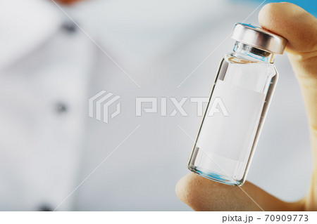 Ampoule and syringe in the hands of a researcher doctor in rubber gloves with a vaccine close-up 70909773
