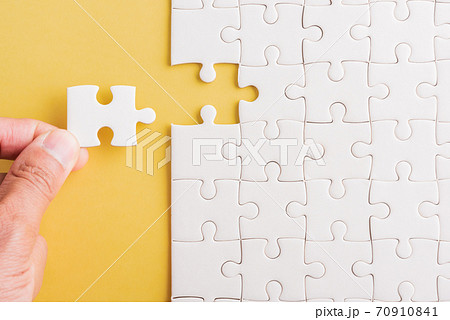 hand-holding last piece white paper jigsaw puzzle game last pieces put to place 70910841