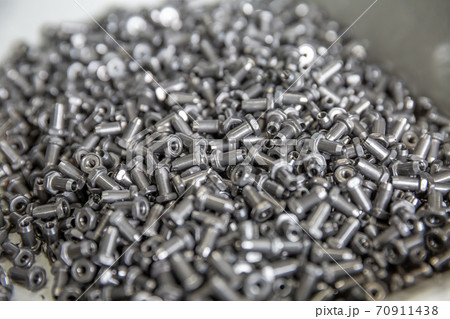 New metal fasteners in the boat in the production of fasteners. Small metal products in oil New metal fasteners in the boat in the production of fasteners. Small metal products in oil 70911438