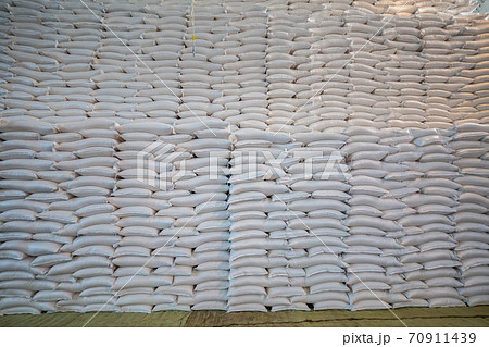 bags of sugar in the warehouse. A wall of sugar sacks in a large warehouse. bags of sugar in the warehouse. A wall of sugar sacks in a large warehouse. 70911439