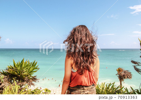 Girl walking through turquoise caribbean sea in Tulum , Mexico 70913363