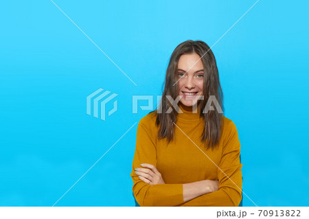 Smiling woman with crossed arms in studio Smiling woman with crossed arms in studio 70913822