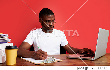 handsome afro american guy is thinking at work, work on laptop 70914347