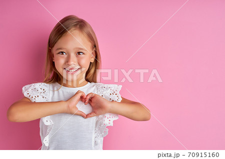 friendly kind girl shows heart made from hands at camera friendly kind girl shows heart made from hands at camera 70915160