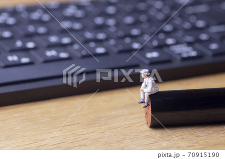 印鑑に座って考える男とパソコンのキーボード 70915190