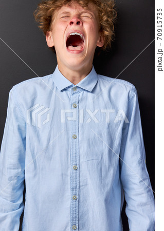 emotional caucasian teen boy is screaming emotional caucasian teen boy is screaming 70915735