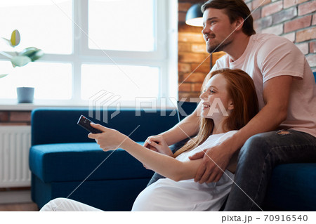 young married couple watch tv together at home 70916540