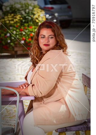Blonde woman with blazer sitting in a cafe 70916797