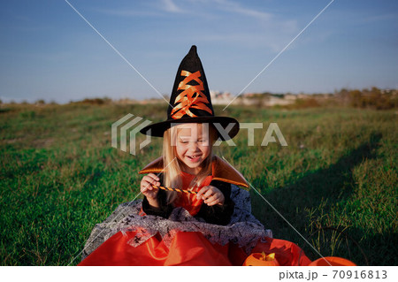 little girl dressed as a witch celebrates halloween 70916813
