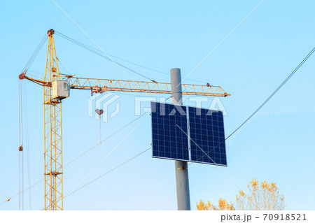 Small solar panel on top electric pole by blue sky 70918521