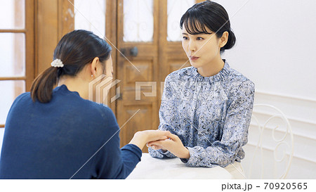 会話する女性　ビューティアドバイザー　占い師　手相占い 70920565