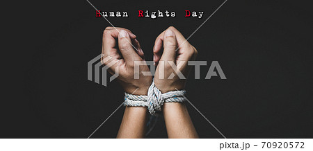Woman hand tied up with rope, depicting the idea of freedom of the press or freedom of expression on dark background in low key. International human right day concept. Woman hand tied up with rope, depicting the idea of freedom of the press or freedom of expression on dark background in low key. International human right day concept. 70920572
